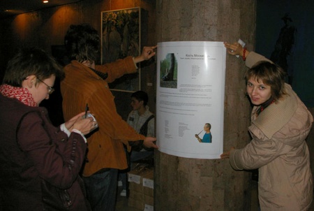 Наклеювання афіші у коридорі Будинку художника