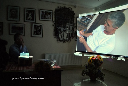 Євген Постульга дивиться на презентацію себе у світлинах, підготовану працівниками Прилуцького краєзнавчого музею